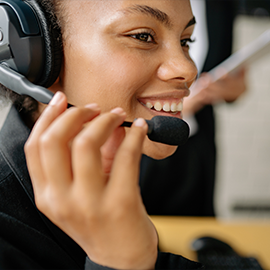 Woman wearing headset listening to customer on phone